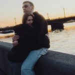 Couple embracing by the river at sunset