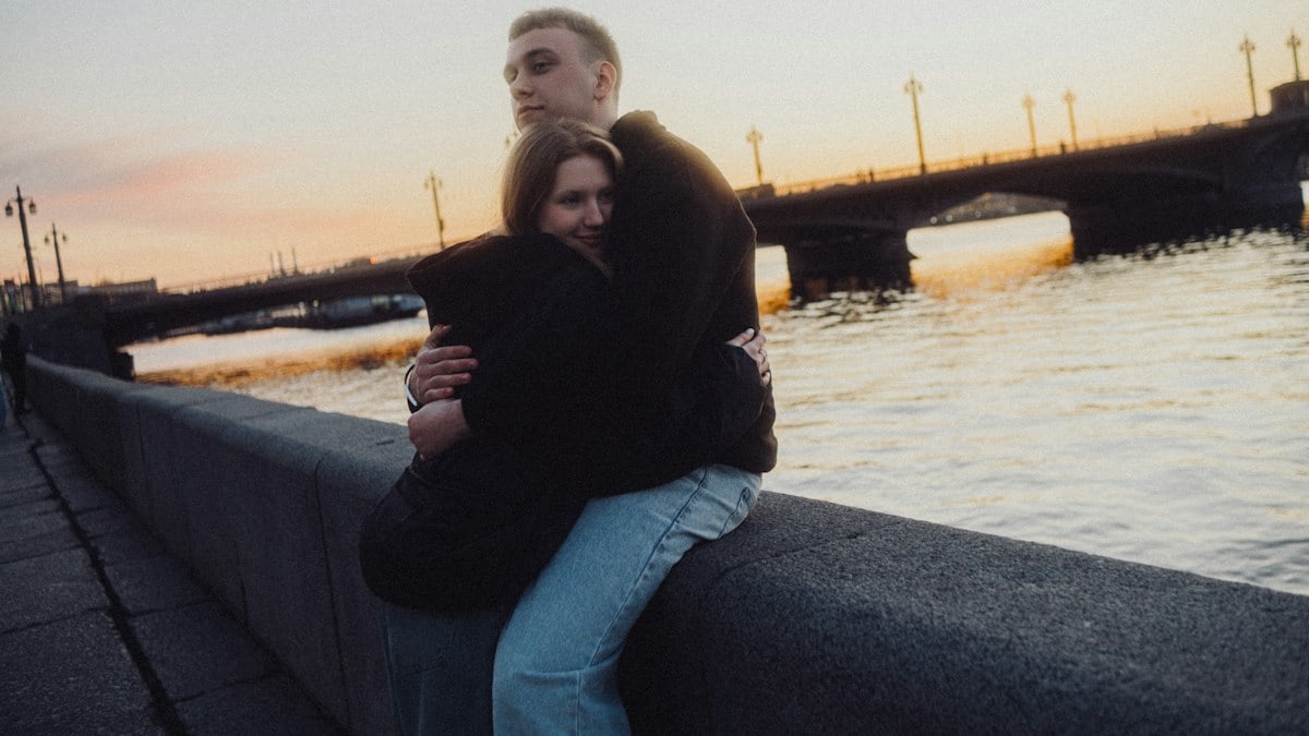 Couple embracing by the river at sunset